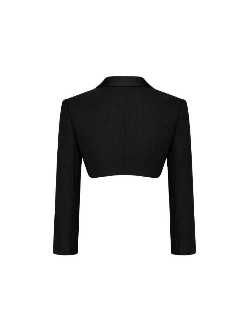 Back view of the Black Cropped Tuxedo Jacket with Jacquard Lapel, showcasing its sharply tailored cropped silhouette and sleek long sleeves for a modern formalwear statement.