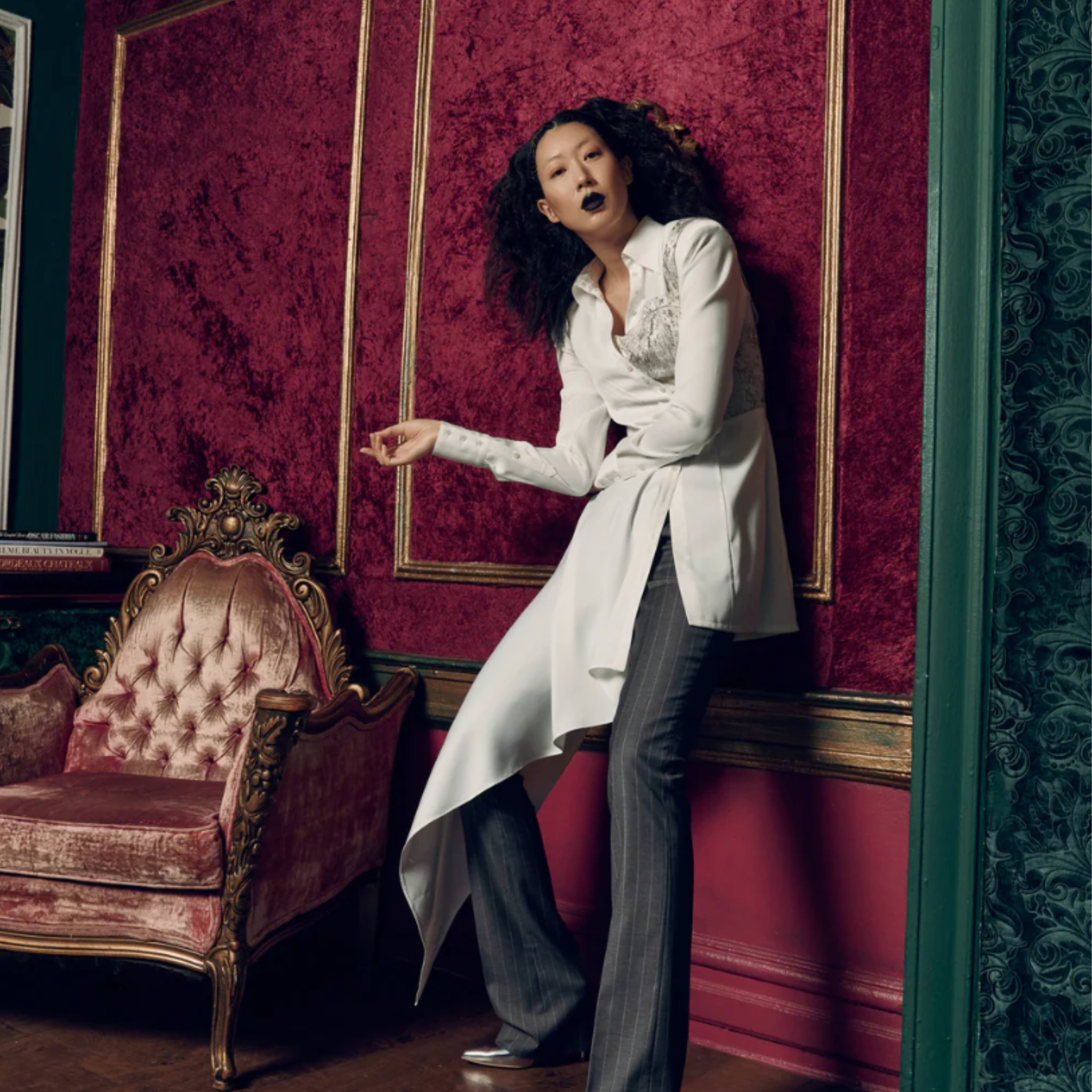 Tailory ivory asymmetric draped shirt styled with tailored pinstripe trousers in an editorial interior setting