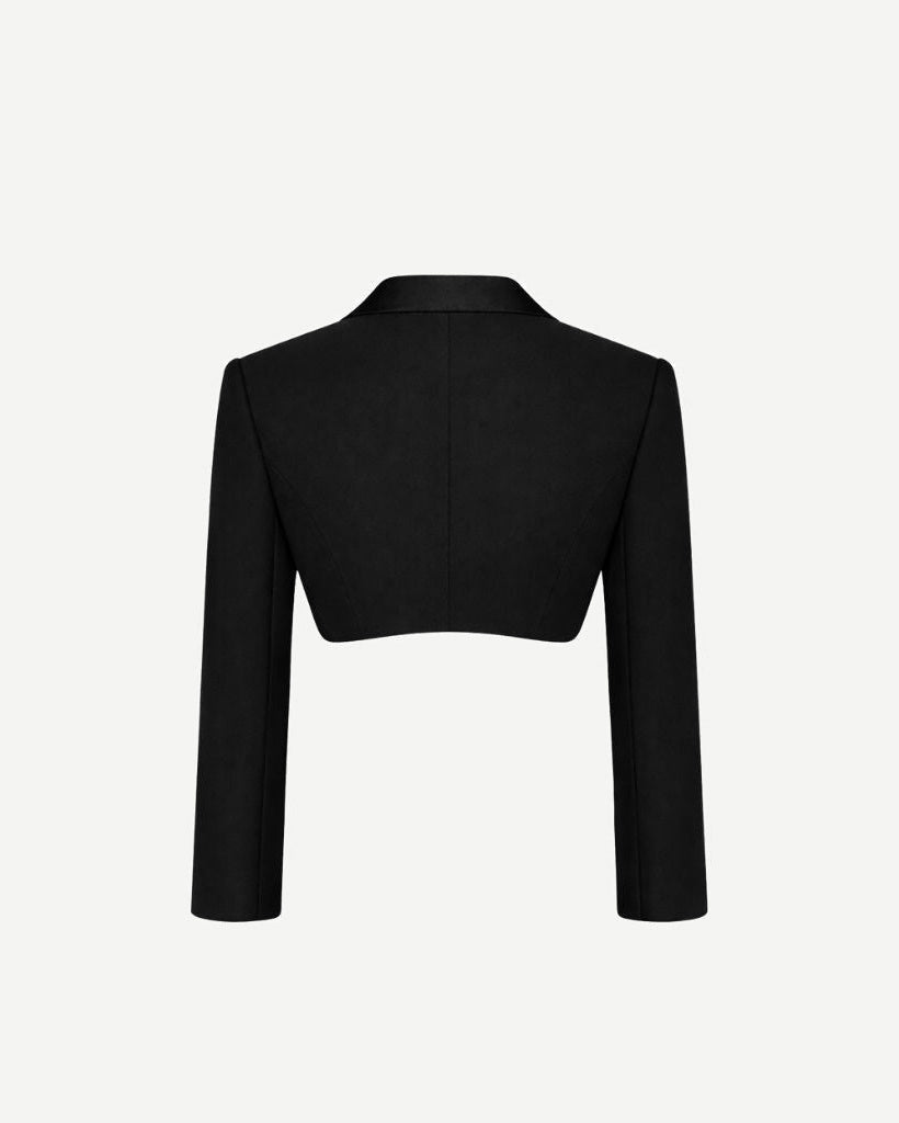 Back view of the Black Cropped Tuxedo Jacket with Jacquard Lapel, showcasing its sharply tailored cropped silhouette and sleek long sleeves for a modern formalwear statement.