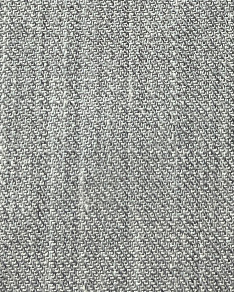 Detailed close-up of Loro Piana Grey Wool Cashmere Blend Jeans fabric, revealing a fine, soft texture in a light grey hue with intricate woven wool and cashmere fibers.