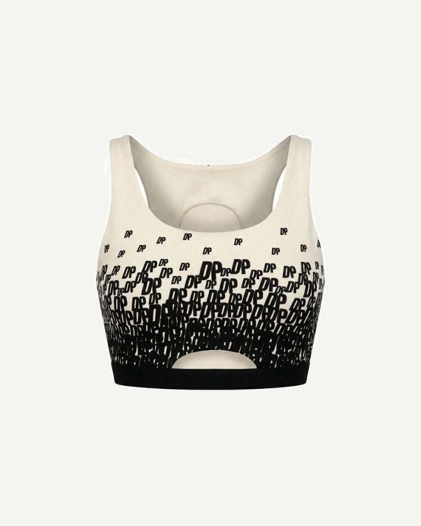 The Tailory New York X Dogpound Cropped Yoga Top in ivory featuring a sleeveless design with a bold black "DP" logo pattern fading upward and a supportive elastic band at the hem.