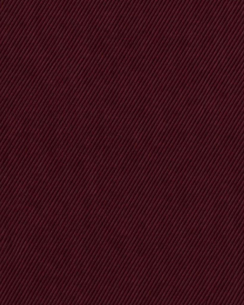 Close-up of deep burgundy wool fabric with fine diagonal ribbing texture, embodying the rich material used in the Burgundy Wool Tuxedo Trousers — Slim Tapered Fit with Satin Waistband.