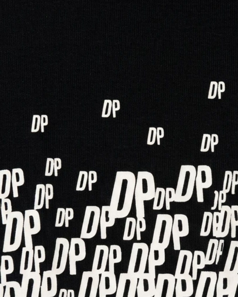 Close-up of black fabric featuring a dynamic white "DP" logo pattern scattered across the surface, part of The Tailory New York X Dogpound Fitted Turtleneck Bodysuit design.