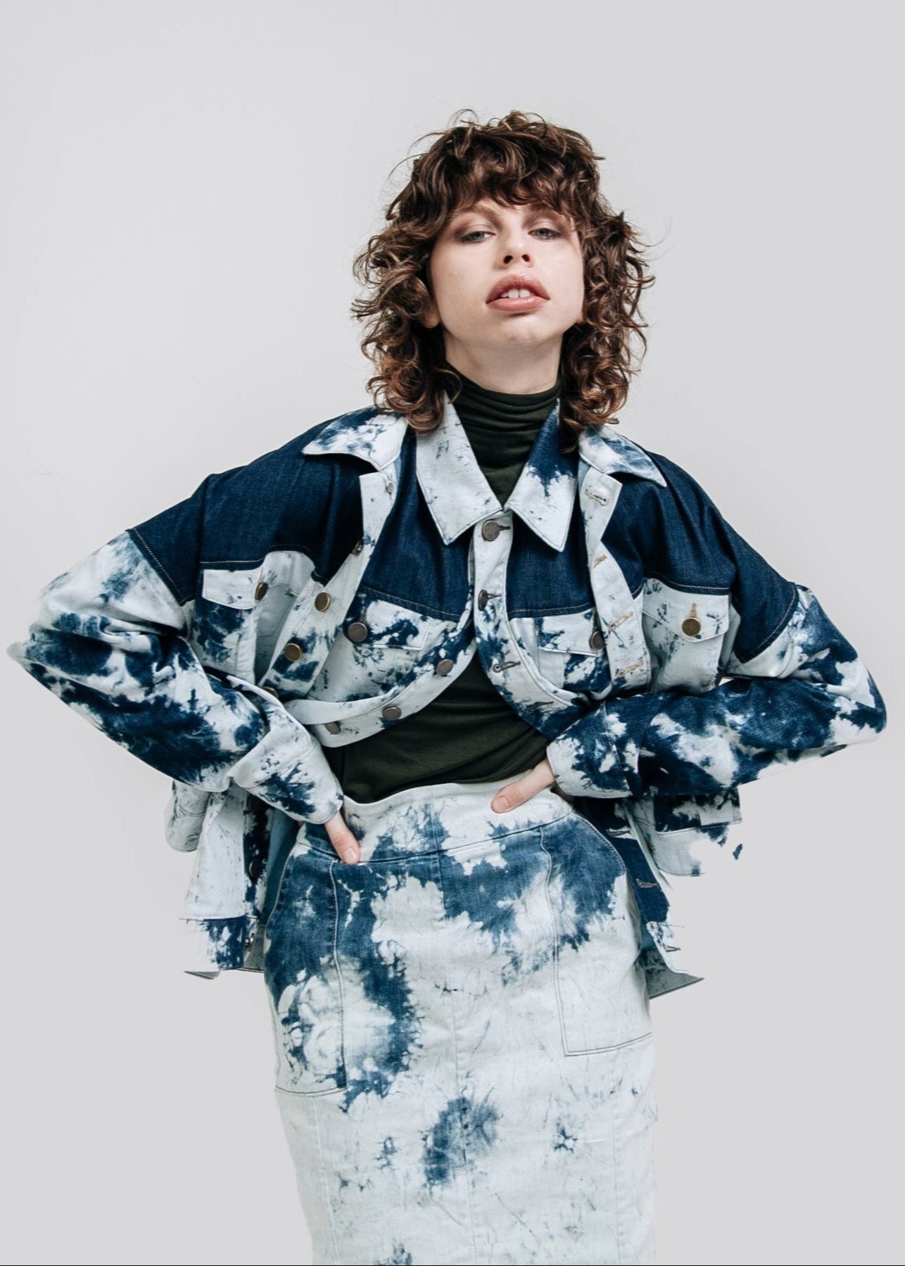 Person wearing a blue and white tie-dye outfit on a plain background