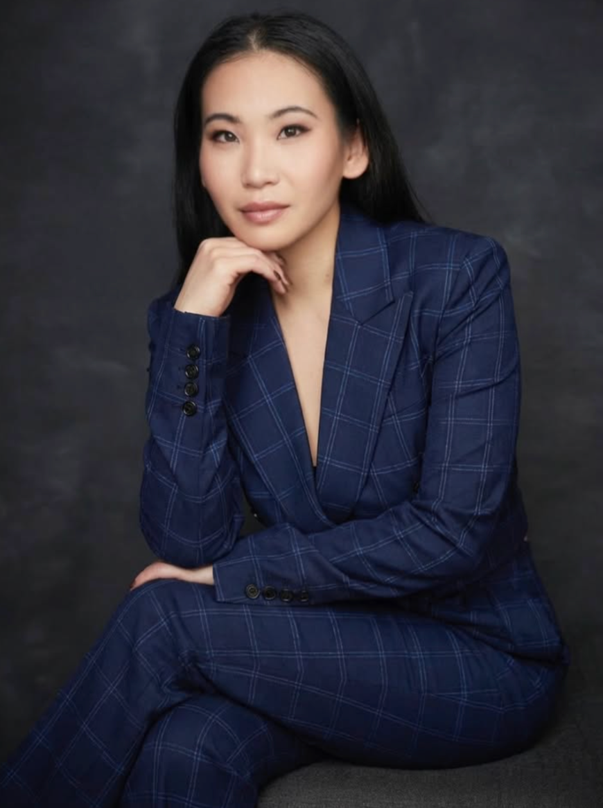 Woman wearing a blue checkered suit against a dark background