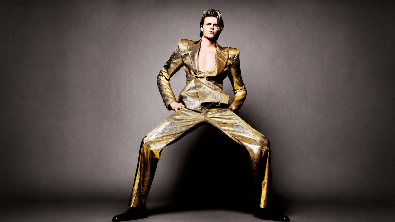 Person wearing a shiny gold outfit on a dark background