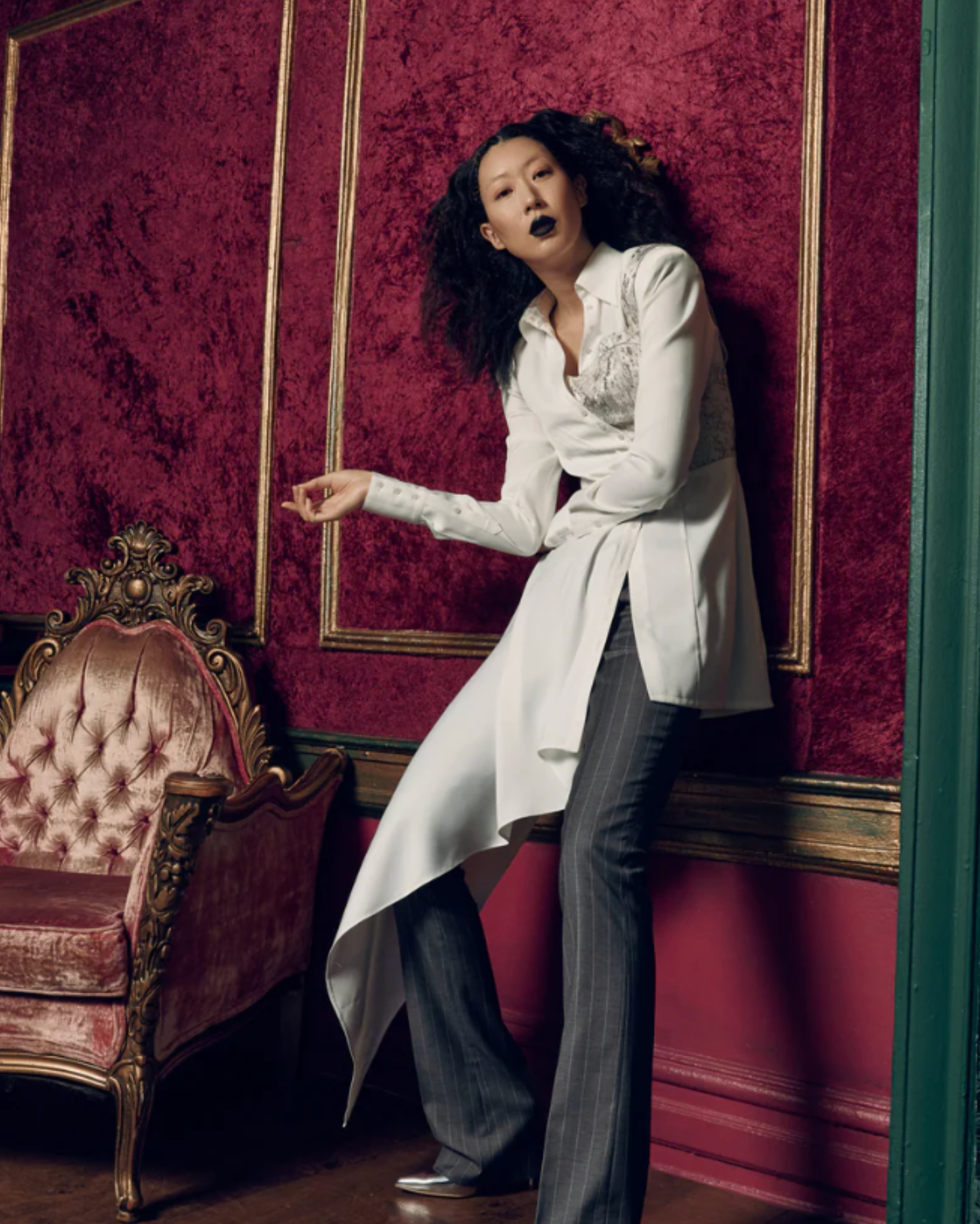 Tailory ivory asymmetric draped shirt styled with tailored pinstripe trousers in an editorial interior setting