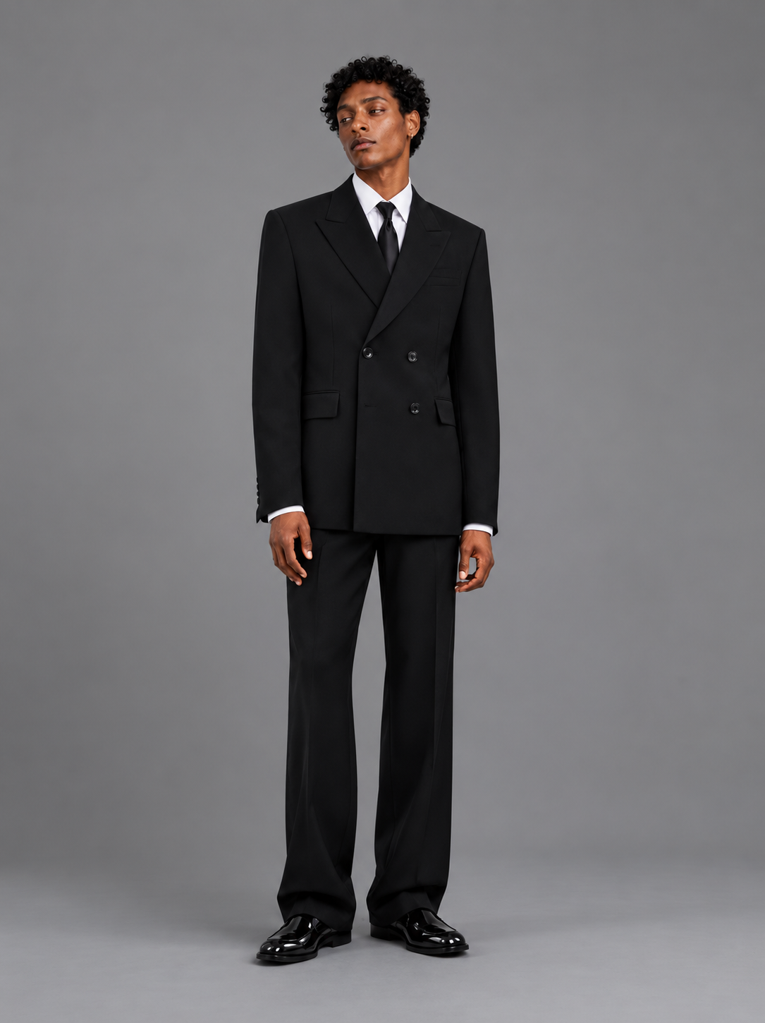Man wearing a black suit against a gray background