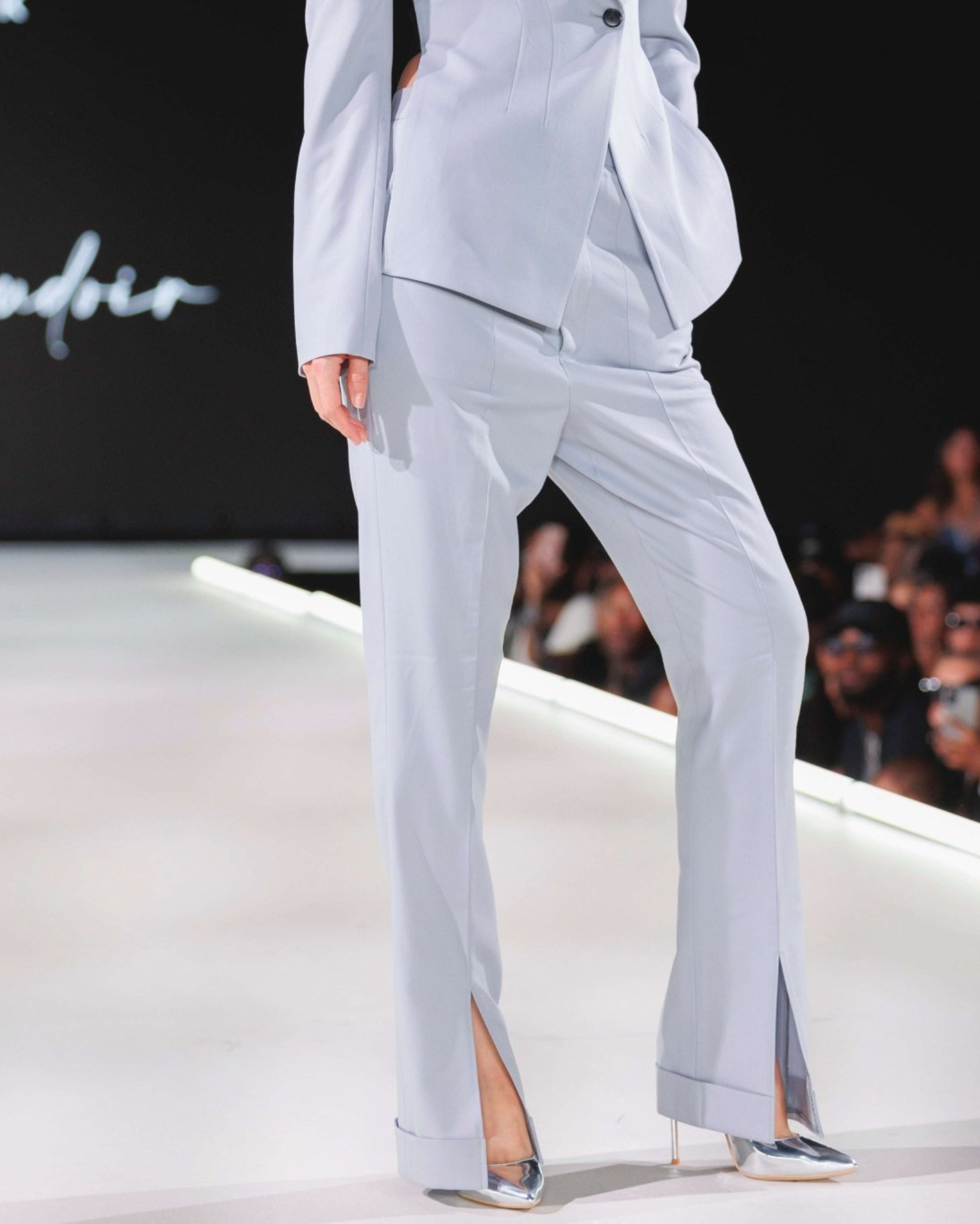 Tailory white flared trousers styled outdoors with front-slit movement
