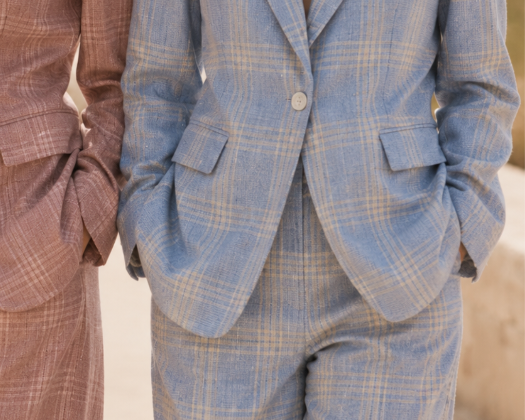 Two people wearing plaid suits with a blurred background