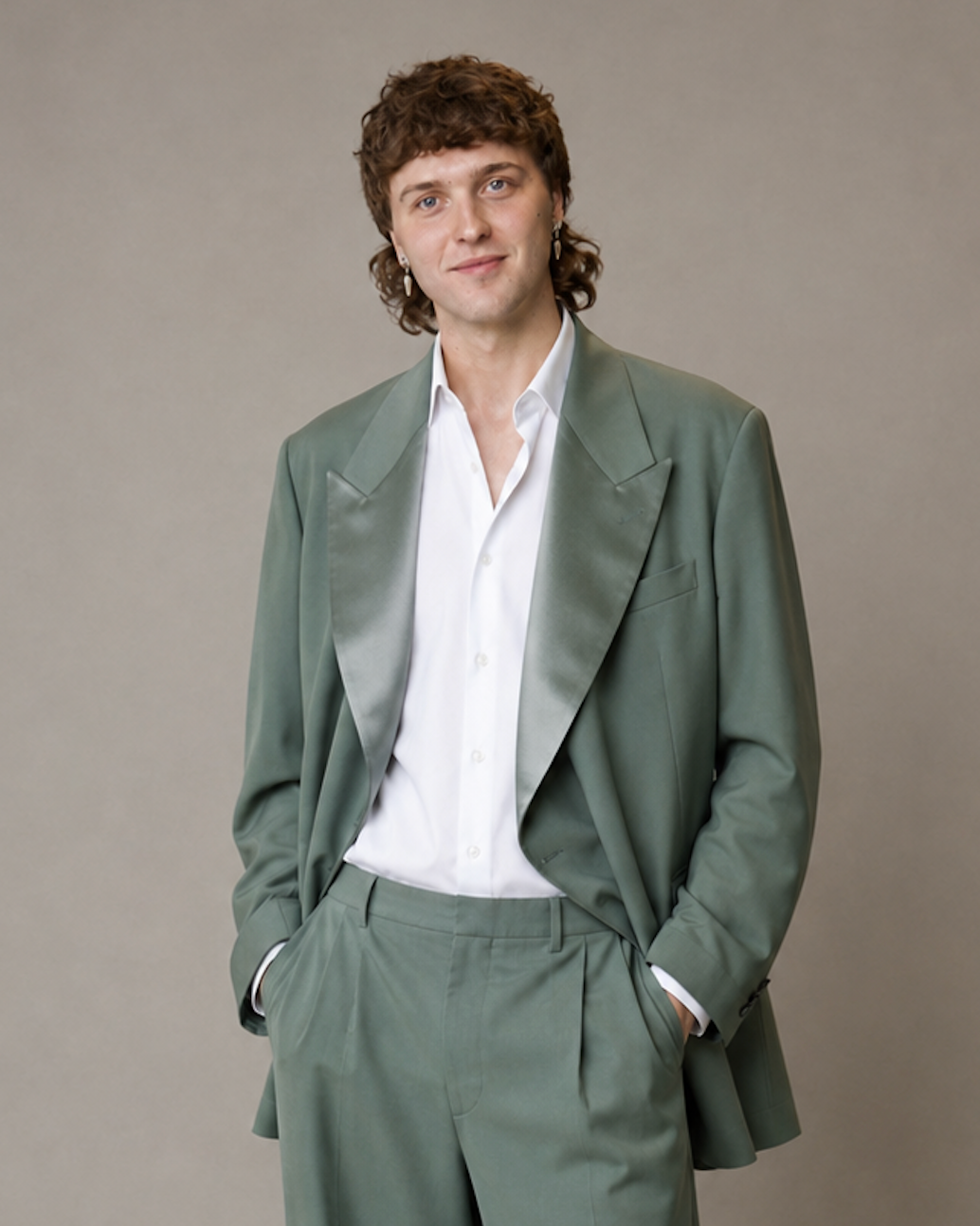 Client in an oversized olive Tailory New York suit with an open ivory shirt