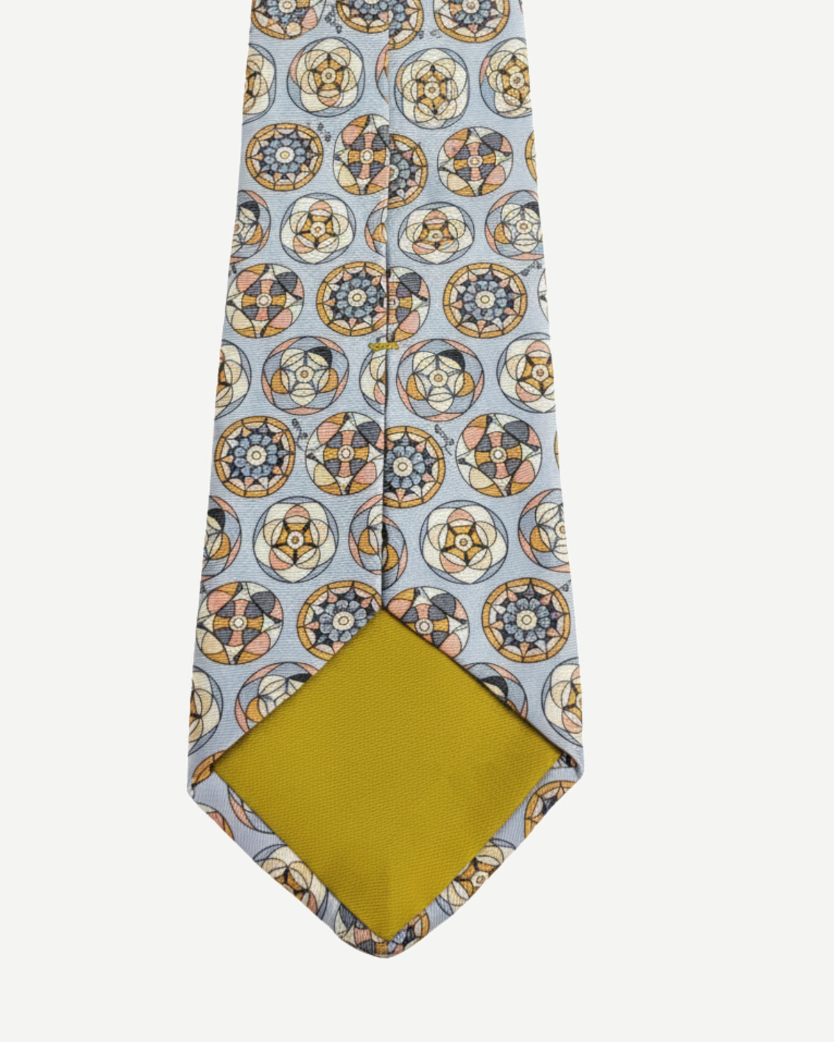 Detail view of medallion pattern silk tie tip and stitching