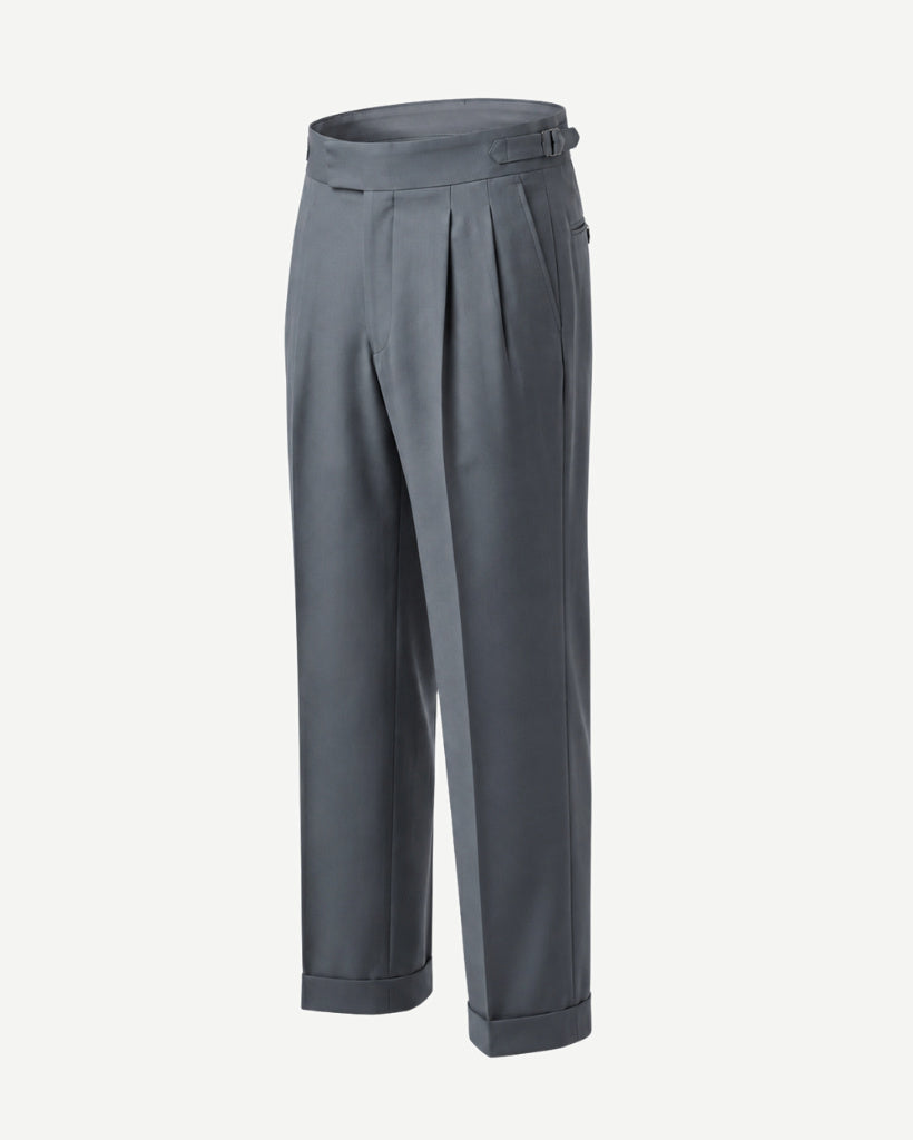 Side view of The Tailory Slate Grey Double-Pleat Wide-Leg Wool Trouser showing the wide-leg silhouette, double pleats, side adjuster, and cuffed hem.