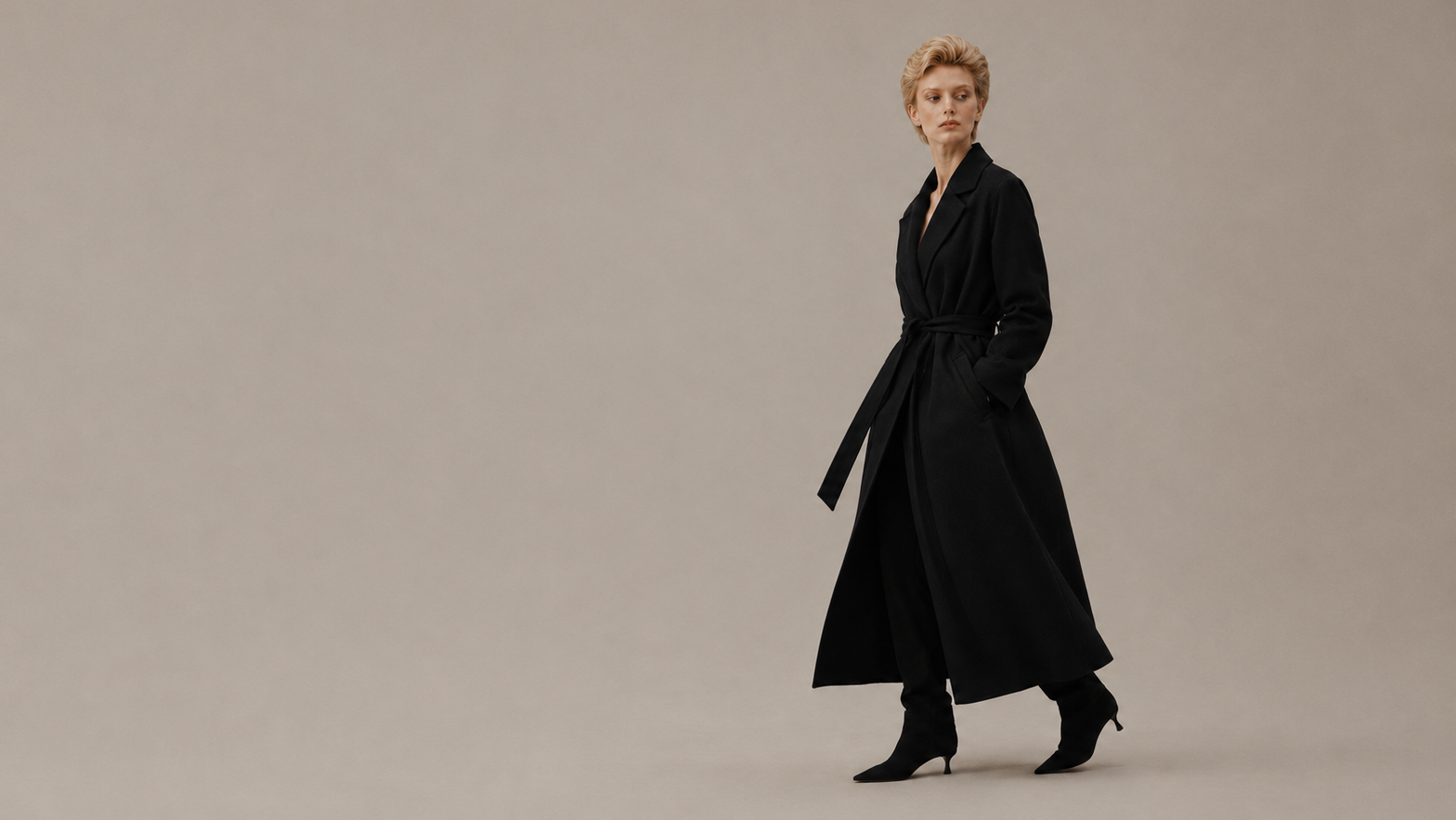 Woman wearing a black coat on a beige background