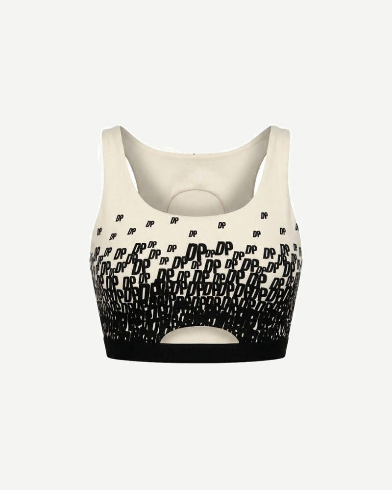 The Tailory New York X Dogpound Cropped Yoga Top in ivory featuring a sleeveless design with a bold black "DP" logo pattern fading upward and a supportive elastic band at the hem.